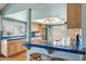 A sunlit kitchen features light wood cabinets, blue tiled countertops, and stainless steel appliances at 4711 S Los Feliz Dr, Tempe, AZ 85282