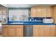 Kitchen sink and counter area with window view, stainless steel dishwasher and light wood cabinets at 4711 S Los Feliz Dr, Tempe, AZ 85282