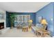 Bright living room featuring a fireplace, large windows, wicker furniture, and blue accent wall at 4711 S Los Feliz Dr, Tempe, AZ 85282