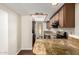 Galley kitchen featuring granite countertops, stainless appliances, and access to laundry at 5208 S Deborah Dr, Tempe, AZ 85283