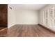 Spacious living room featuring attractive wood floors and shuttered doors at 5208 S Deborah Dr, Tempe, AZ 85283