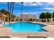 Sparkling community pool with clear blue water, surrounded by palm trees, and lounge chairs for relaxation at 5208 S Deborah Dr, Tempe, AZ 85283