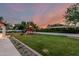 Large grassy backyard with a playhouse and mature hedges in a peaceful setting at 5602 W Alameda Rd, Glendale, AZ 85310