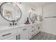 Modern bathroom with dual sinks, black fixtures, round mirrors, and patterned tile flooring at 5602 W Alameda Rd, Glendale, AZ 85310