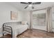 Simple bedroom with a metal bed frame, ceiling fan, and wood flooring at 5602 W Alameda Rd, Glendale, AZ 85310