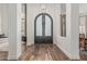 Grand foyer with hardwood floors, arched doorways, and a modern light fixture at 5602 W Alameda Rd, Glendale, AZ 85310