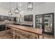 Well-lit kitchen featuring dark cabinets, brick backsplash, and a rustic wooden table island at 5602 W Alameda Rd, Glendale, AZ 85310