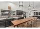 Stylish kitchen with dark cabinetry, brick backsplash, wooden island and modern light fixtures at 5602 W Alameda Rd, Glendale, AZ 85310