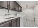 Laundry room with sleek countertops, dark cabinetry, modern sink, and new appliances at 5602 W Alameda Rd, Glendale, AZ 85310