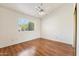 Neutral bedroom with wood floors, large window, and ceiling fan at 5852 E Enrose St, Mesa, AZ 85205