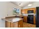 Well-lit kitchen featuring a breakfast bar and black appliances at 5852 E Enrose St, Mesa, AZ 85205