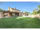Large backyard showcasing a covered patio, lush green lawn, and a sparkling pool for outdoor enjoyment at 6101 W Grandview Rd, Glendale, AZ 85306