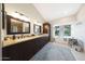 Bright bathroom with granite countertops, dark wood cabinets, and a soaking tub beneath a window with a view at 6101 W Grandview Rd, Glendale, AZ 85306