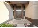 Grand front entrance featuring a decorative door, accent lighting, and well-manicured landscaping at 6101 W Grandview Rd, Glendale, AZ 85306