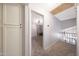 Hallway leading to bedroom with ceiling fan, neutral carpet, and bonus storage cupboard at 6101 W Grandview Rd, Glendale, AZ 85306