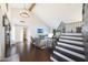 Bright living room featuring a vaulted ceiling, staircase, hardwood floors, and comfortable seating with a view to the entry at 6101 W Grandview Rd, Glendale, AZ 85306