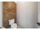 A powder room featuring wood-look accent wall and toilet at 6101 W Grandview Rd, Glendale, AZ 85306