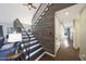 Stylish staircase with a metal railing, hardwood steps and planked wall, leading to the upper level of the home at 6101 W Grandview Rd, Glendale, AZ 85306