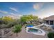 An aerial view of a backyard oasis featuring a pool, lounge area, desert landscaping, and a covered patio at 6765 E Duane Ln, Scottsdale, AZ 85266