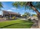 Expansive backyard featuring a covered patio, lush landscaping, and a well-maintained lawn at 6765 E Duane Ln, Scottsdale, AZ 85266