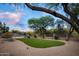 Desert landscaped backyard with green lawn, pool, mature trees and privacy fence at 6765 E Duane Ln, Scottsdale, AZ 85266