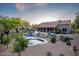 Wide view of the expansive backyard featuring a pool, lounge area, desert landscaping and a covered patio at 6765 E Duane Ln, Scottsdale, AZ 85266