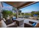 Covered outdoor patio with seating, providing a relaxing view of the backyard oasis and desert landscaping at 6765 E Duane Ln, Scottsdale, AZ 85266