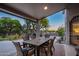 Covered patio area featuring a dining table and chairs, barbecue, and lush backyard views, perfect for outdoor dining at 6765 E Duane Ln, Scottsdale, AZ 85266