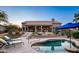 Inviting backyard pool area featuring a baja shelf, desert landscaping, and covered patio with furniture and lounge chairs at 6765 E Duane Ln, Scottsdale, AZ 85266
