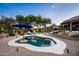Desert backyard featuring a pool, desert landscaping, lounge chairs, and shade provided by a large patio umbrella at 6765 E Duane Ln, Scottsdale, AZ 85266