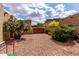Backyard with gravel, gate and desert landscaping, offering privacy and charm at 9938 E Little Nugget Way, Gold Canyon, AZ 85118