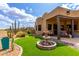 Inviting backyard with fountain, artificial turf, lush desert landscaping, and a covered patio at 9938 E Little Nugget Way, Gold Canyon, AZ 85118