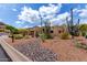 Santa Fe home with desert landscaping in the front yard and a two-car garage at 9938 E Little Nugget Way, Gold Canyon, AZ 85118