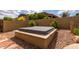 Backyard hot tub with stone surround set amidst desert landscaping, providing a serene retreat at 9938 E Little Nugget Way, Gold Canyon, AZ 85118