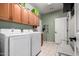 Well-lit laundry room featuring modern washer and dryer units with convenient overhead cabinet storage at 9938 E Little Nugget Way, Gold Canyon, AZ 85118