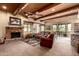 Comfortable living room with wood beams, fireplace, and a view into the dining area at 9938 E Little Nugget Way, Gold Canyon, AZ 85118
