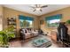 Cozy living room with a ceiling fan, area rug, and large windows overlooking the exterior at 9938 E Little Nugget Way, Gold Canyon, AZ 85118