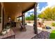 Covered patio with an outdoor kitchen, bar seating, and a cozy fireplace for entertaining guests at 9938 E Little Nugget Way, Gold Canyon, AZ 85118
