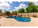 Inviting backyard pool with lush landscaping and a tranquil waterfall feature, perfect for relaxation and enjoyment at 9938 E Little Nugget Way, Gold Canyon, AZ 85118