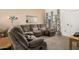 Spacious living room featuring a plush sectional sofa, soft carpet, and bright natural light at 10040 W Royal Oak Rd # N, Sun City, AZ 85351