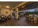 Back patio with fire pit, outdoor kitchen with bar seating, and a covered dining and lounge area with string lights at 10154 E Bergeron Ave, Mesa, AZ 85212