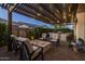 Back patio with outdoor kitchen and bar, fire pit and lounge area all surrounded by lush landscaping at 10154 E Bergeron Ave, Mesa, AZ 85212
