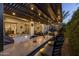 Back patio with outdoor kitchen, bar seating and string lights over a covered patio with lounge seating at 10154 E Bergeron Ave, Mesa, AZ 85212