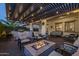 Inviting back patio featuring a fire pit, seating under a pergola with string lights, and an outdoor kitchen at 10154 E Bergeron Ave, Mesa, AZ 85212