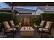 Back patio featuring a fountain, fire pit, lush landscaping, and string lights, great for outdoor entertaining at 10154 E Bergeron Ave, Mesa, AZ 85212