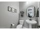 Charming powder room featuring a pedestal sink, framed artwork, and stylish decor at 10154 E Bergeron Ave, Mesa, AZ 85212