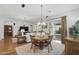 Open-concept dining room featuring hardwood floors, a chandelier, and views of the living room and patio at 10154 E Bergeron Ave, Mesa, AZ 85212