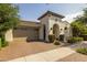 Stylish home featuring a terracotta roof, a two-car garage, and lush landscaping at 10154 E Bergeron Ave, Mesa, AZ 85212