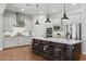 Modern kitchen featuring a large island, stainless steel appliances, white cabinets, and hardwood floors at 10154 E Bergeron Ave, Mesa, AZ 85212
