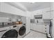 Well-organized laundry room with white cabinetry, stainless steel appliances, and ample shelving at 10154 E Bergeron Ave, Mesa, AZ 85212